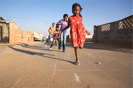 simsearch:873-07156810,k - Girls playing hopscotch on street Photographie de stock - Premium Libres de Droits, Code: 6110-07233624