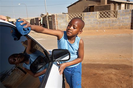 Boy cleaning car with towel Stock Photo - Premium Royalty-Free, Code: 6110-07233634