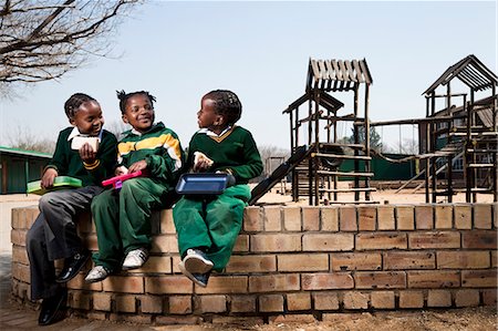 dreadlocks on african americans - Three girls sitting on a wall eating their lunch, Meyerton Primary School, Meyerton, Gauteng Foto de stock - Sin royalties Premium, Código: 6110-08780341