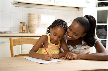 simsearch:6110-06702656,k - Young African mother helping her daughter with her homework Foto de stock - Royalty Free Premium, Número: 6110-08968690