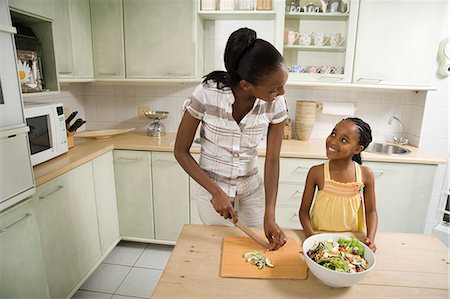 simsearch:6110-06702795,k - Young African woman making a salad with her daughter in a kitchen Foto de stock - Royalty Free Premium, Número: 6110-08968697