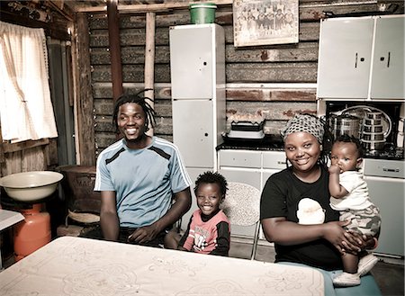 simsearch:6110-06702795,k - African family stand together in their rural home, smiling at camera Foto de stock - Royalty Free Premium, Número: 6110-08968625