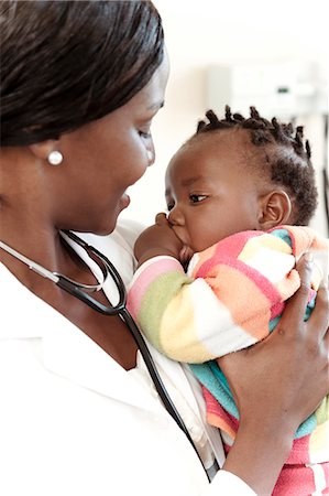 simsearch:6110-06702748,k - Closeup of an African female doctor holding an infant Foto de stock - Royalty Free Premium, Número: 6110-08968767