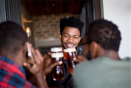 simsearch:659-02211460,k - Three men toasting at a bar Fotografie stock - Premium Royalty-Free, Codice: 6110-09101677