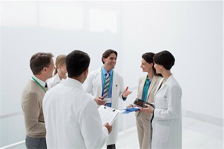 Smiling doctors discussing medical charts Fotografie stock - Premium Royalty-Free, Codice: 6113-06497779