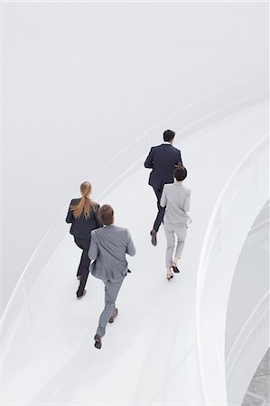 person rushing - Business people running along elevated walkway Stock Photo - Premium Royalty-Free, Code: 6113-06497789