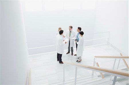 Doctors meeting on landing of stairs Stock Photo - Premium Royalty-Free, Code: 6113-06497790
