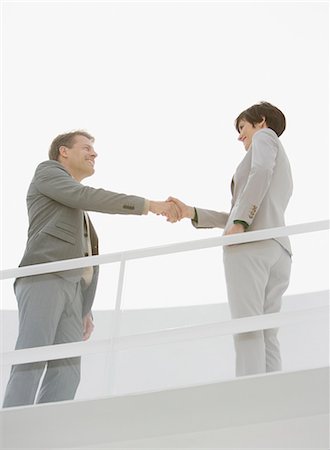 Businessman and businesswoman shaking hands Stock Photo - Premium Royalty-Free, Code: 6113-06497842