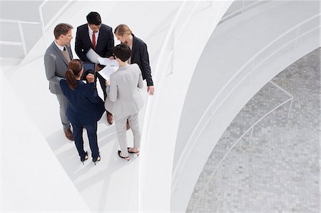 ethnic team business - Business people reviewing paperwork on elevated walkway Stock Photo - Premium Royalty-Free, Code: 6113-06497853