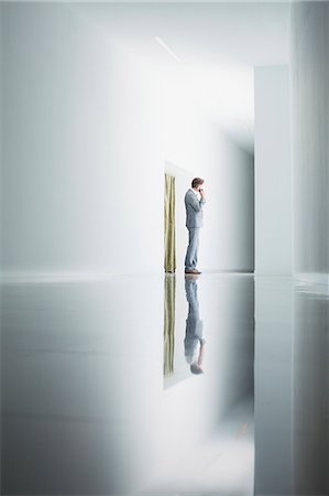 simsearch:6113-06498783,k - Businessman on cell phone in corridor Stock Photo - Premium Royalty-Free, Code: 6113-06497860