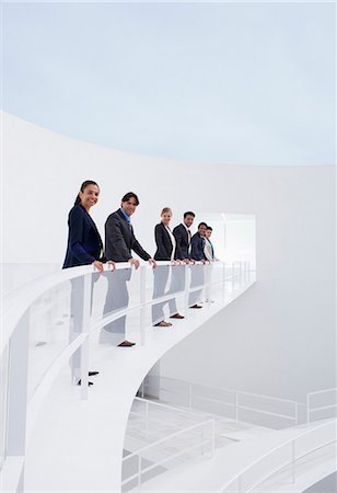 Portrait of smiling business people leaning on railing of elevated walkway Photographie de stock - Premium Libres de Droits, Code: 6113-06497871