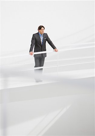 Businessman leaning on railing at elevated walkway Stock Photo - Premium Royalty-Free, Code: 6113-06497878