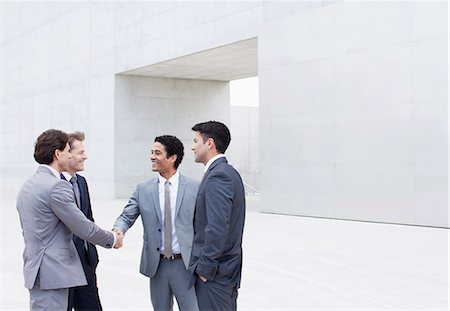 simsearch:6113-06497888,k - Smiling businessmen shaking hands outside cultural center Stock Photo - Premium Royalty-Free, Code: 6113-06497888
