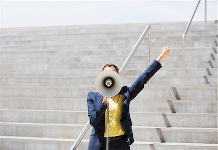 Businesswoman using megaphone on urban steps Photographie de stock - Premium Libres de Droits, Code: 6113-06497822