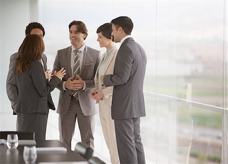 Business people talking at window of conference room Stock Photo - Premium Royalty-Free, Code: 6113-06497948