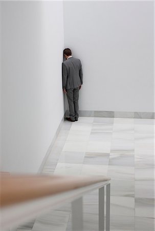 Dejected businessman standing in corner Fotografie stock - Premium Royalty-Free, Codice: 6113-06497958