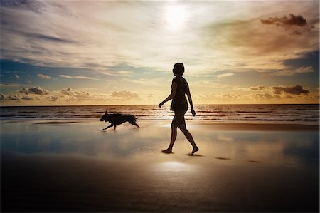 sunrise sea dog - Silhouette of woman and dog walking on beach Stock Photo - Premium Royalty-Free, Code: 6113-06497967