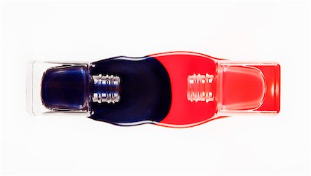 Blue and coral fingernail polish spilling from bottles Stock Photo - Premium Royalty-Free, Code: 6113-06497990