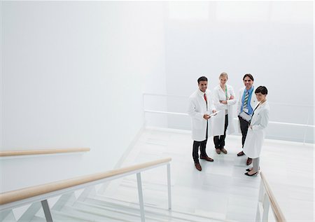 Portrait of smiling doctors on landing of stairs Photographie de stock - Premium Libres de Droits, Code: 6113-06497906