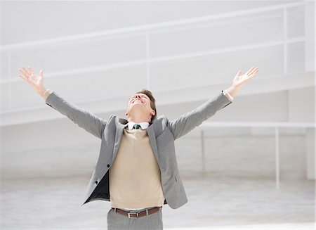 excited man arm raise - Exuberant businessman with head back and arms outstretched Stock Photo - Premium Royalty-Free, Code: 6113-06497916