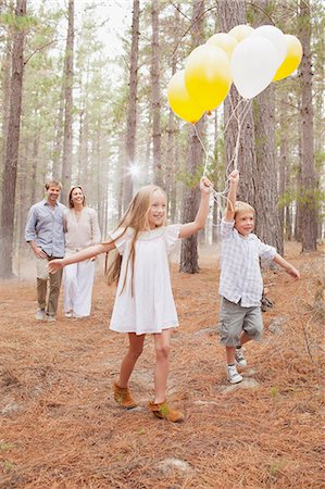 family walking smile - Happy family with balloons in woods Foto de stock - Sin royalties Premium, Código: 6113-06498054