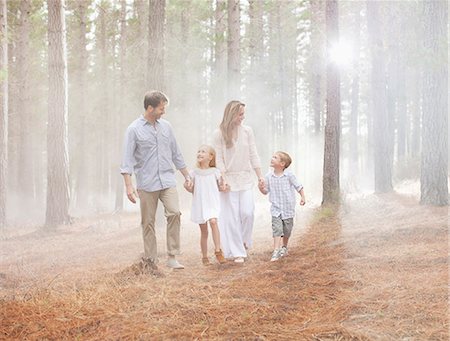 family walking outdoors - Happy family walking in sunny woods Photographie de stock - Premium Libres de Droits, Code: 6113-06498066