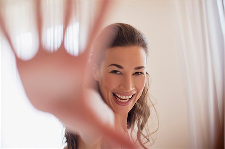 reaching - Portrait of smiling woman with hand outstretched Stock Photo - Premium Royalty-Free, Code: 6113-06498145