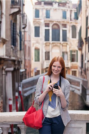 Portrait of smiling woman with camera in Venice Foto de stock - Sin royalties Premium, Código: 6113-06498150