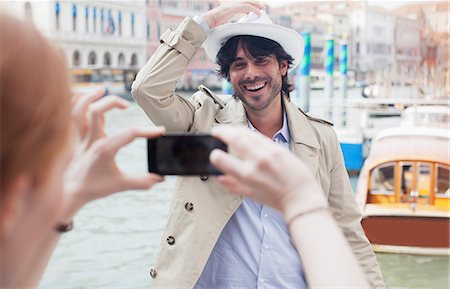 Woman with camera phone photographing man at waterfront in Venice Stock Photo - Premium Royalty-Free, Code: 6113-06498166