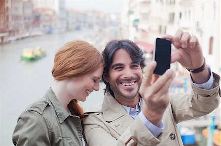 Laughing couple taking self-portrait with camera phone on canal in Venice Foto de stock - Sin royalties Premium, Código: 6113-06498185