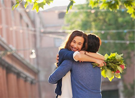 receiving - Smiling woman with flowers hugging man Stock Photo - Premium Royalty-Free, Code: 6113-06498101