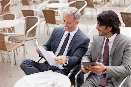 simsearch:6113-06498815,k - Smiling businessmen with digital tablet and paperwork in cafe Stock Photo - Premium Royalty-Free, Code: 6113-06498243