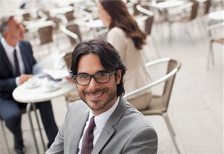 Portrait of smiling businessman at sidewalk cafe Stock Photo - Premium Royalty-Free, Code: 6113-06498219