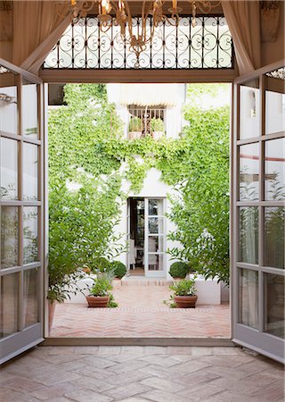 View of courtyard through French doors Photographie de stock - Premium Libres de Droits, Code: 6113-06498343