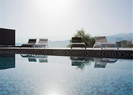 simsearch:6113-06498845,k - Sun shining over lounge chairs and swimming pool Stockbilder - Premium RF Lizenzfrei, Bildnummer: 6113-06498398