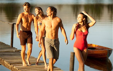 simsearch:6113-06498552,k - Smiling couples walking on dock over lake Stock Photo - Premium Royalty-Free, Code: 6113-06498496