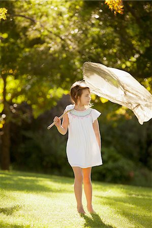 Girl carrying butterfly net in grass Stock Photo - Premium Royalty-Free, Code: 6113-06498571