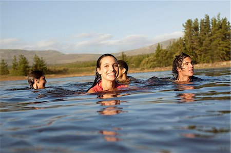 swimming in lake summer - Smiling friends swimming in lake Stock Photo - Premium Royalty-Free, Code: 6113-06498525