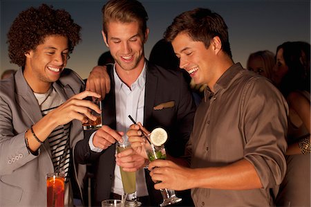 simsearch:6116-07235662,k - Smiling men toasting cocktails in nightclub Stock Photo - Premium Royalty-Free, Code: 6113-06498644