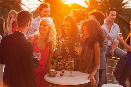 party full body - Smiling friends drinking cocktails on sunny balcony Stock Photo - Premium Royalty-Free, Code: 6113-06498648