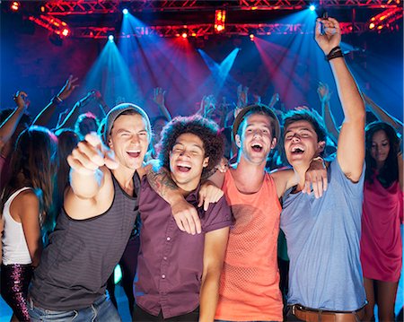 party indoors night - Enthusiastic friends cheering on dance floor of nightclub Stock Photo - Premium Royalty-Free, Code: 6113-06498653