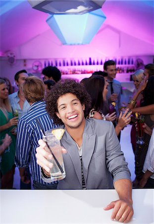 simsearch:6113-06498621,k - Portrait of smiling man holding cocktail at bar of nightclub Stock Photo - Premium Royalty-Free, Code: 6113-06498604