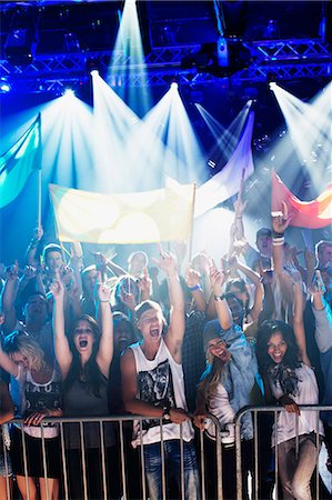 ethnic teens backlit - Crowd cheering with arms raised behind railing at concert Stock Photo - Premium Royalty-Free, Code: 6113-06498606