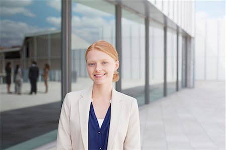 red haired business woman - Portrait of smiling businesswoman outside building Stock Photo - Premium Royalty-Free, Code: 6113-06498840