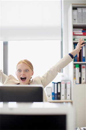 Exuberant businesswoman at computer in office Foto de stock - Sin royalties Premium, Código: 6113-06498848