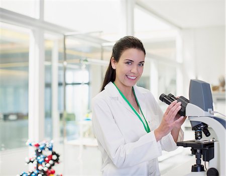 portrait of a woman and healthcare - Portrait of confident scientist using microscope in laboratory Stock Photo - Premium Royalty-Free, Code: 6113-06498855