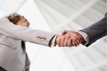 Close up of businessman and businesswoman shaking hands Photographie de stock - Premium Libres de Droits, Code: 6113-06498813