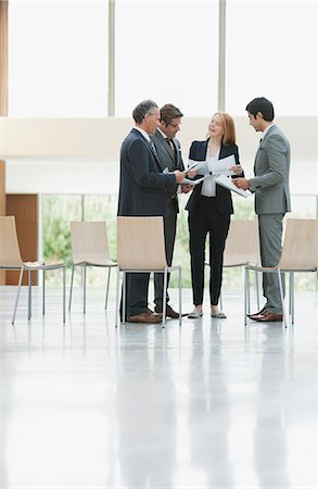 diversity team - Business people reviewing paperwork in lobby Stock Photo - Premium Royalty-Free, Code: 6113-06498839