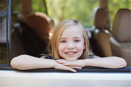 Smiling girl leaning out car window Stock Photo - Premium Royalty-Free, Code: 6113-06498942