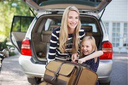 Mother and daughter carrying luggage to car Stock Photo - Premium Royalty-Free, Code: 6113-06498991